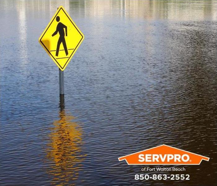 A pedestrian street sign stands in five feet of floodwater.