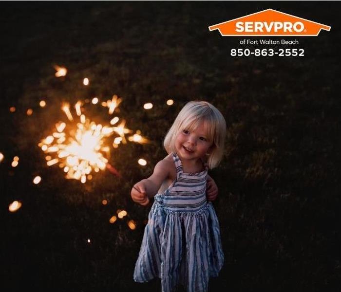 A little girl is holding a sparkler.